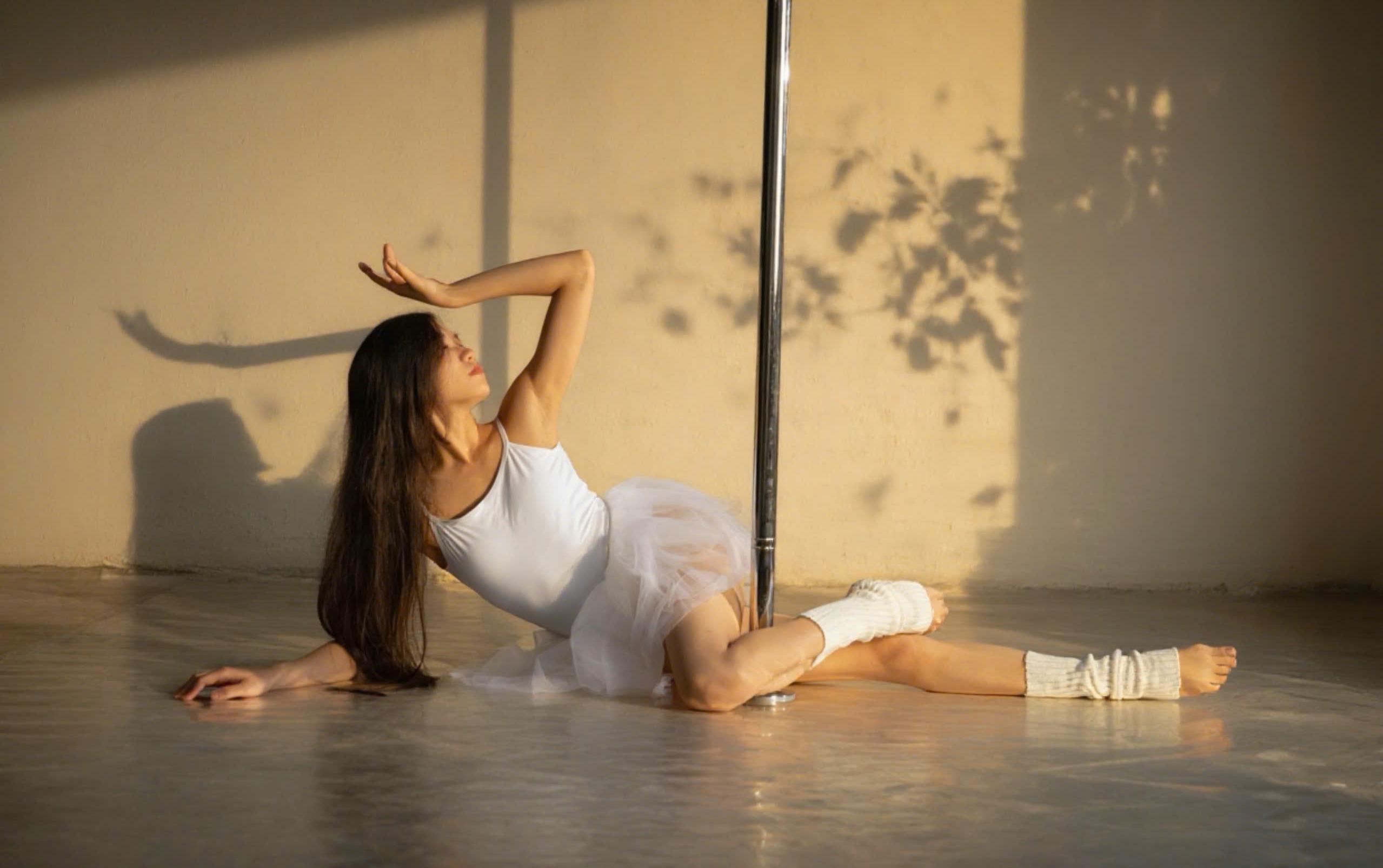 Thảo Nhi performing a backbend pole pose, arm extended overhead